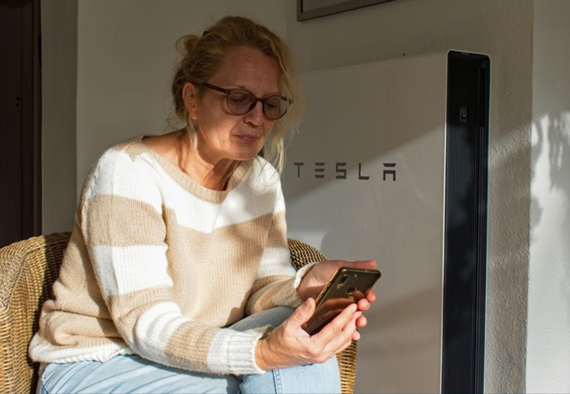 Woman sitting in Tesla dealership after referring a friend to their customer referral programme